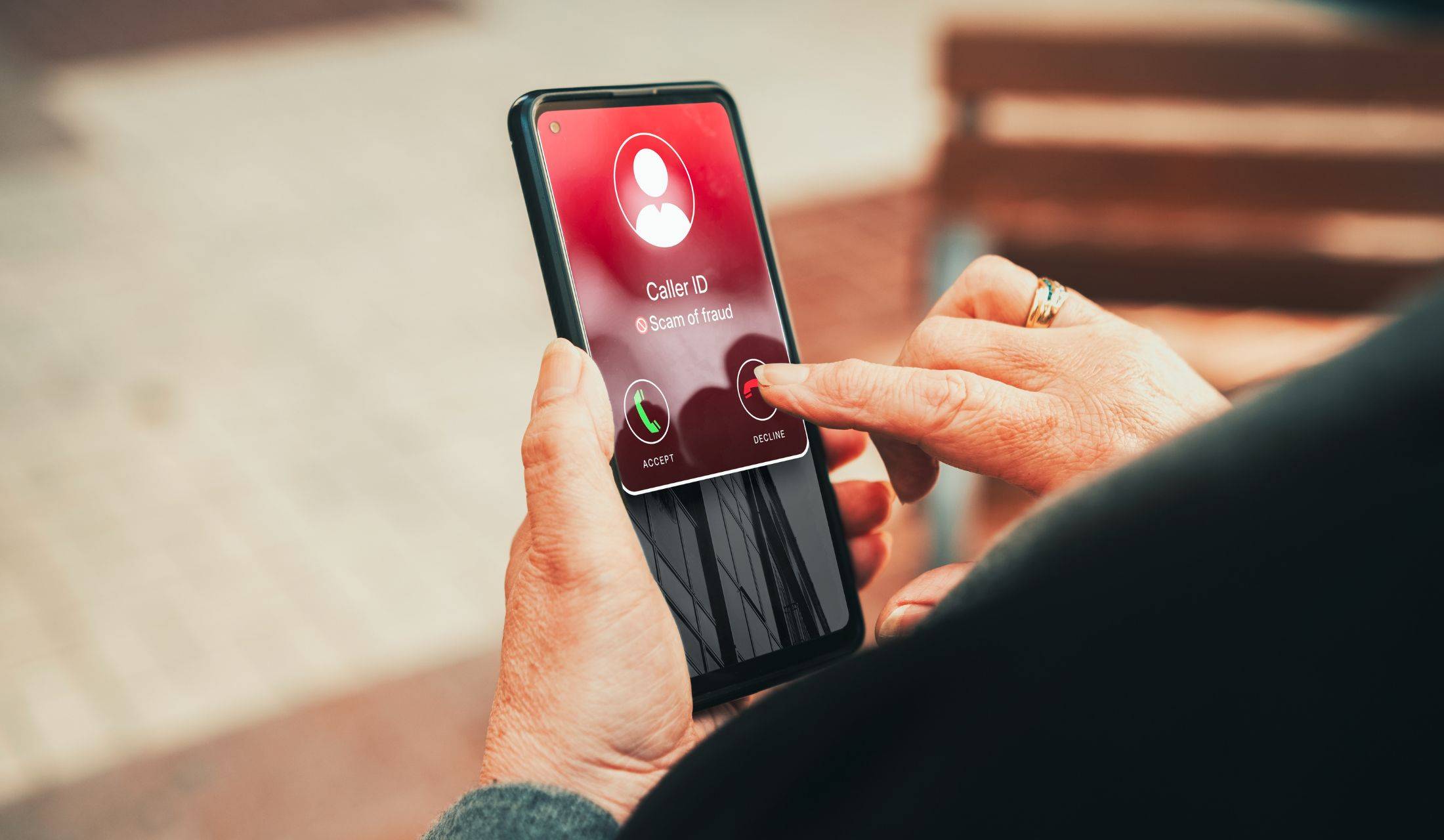 Scam call to phone with person's hand about to decline the call