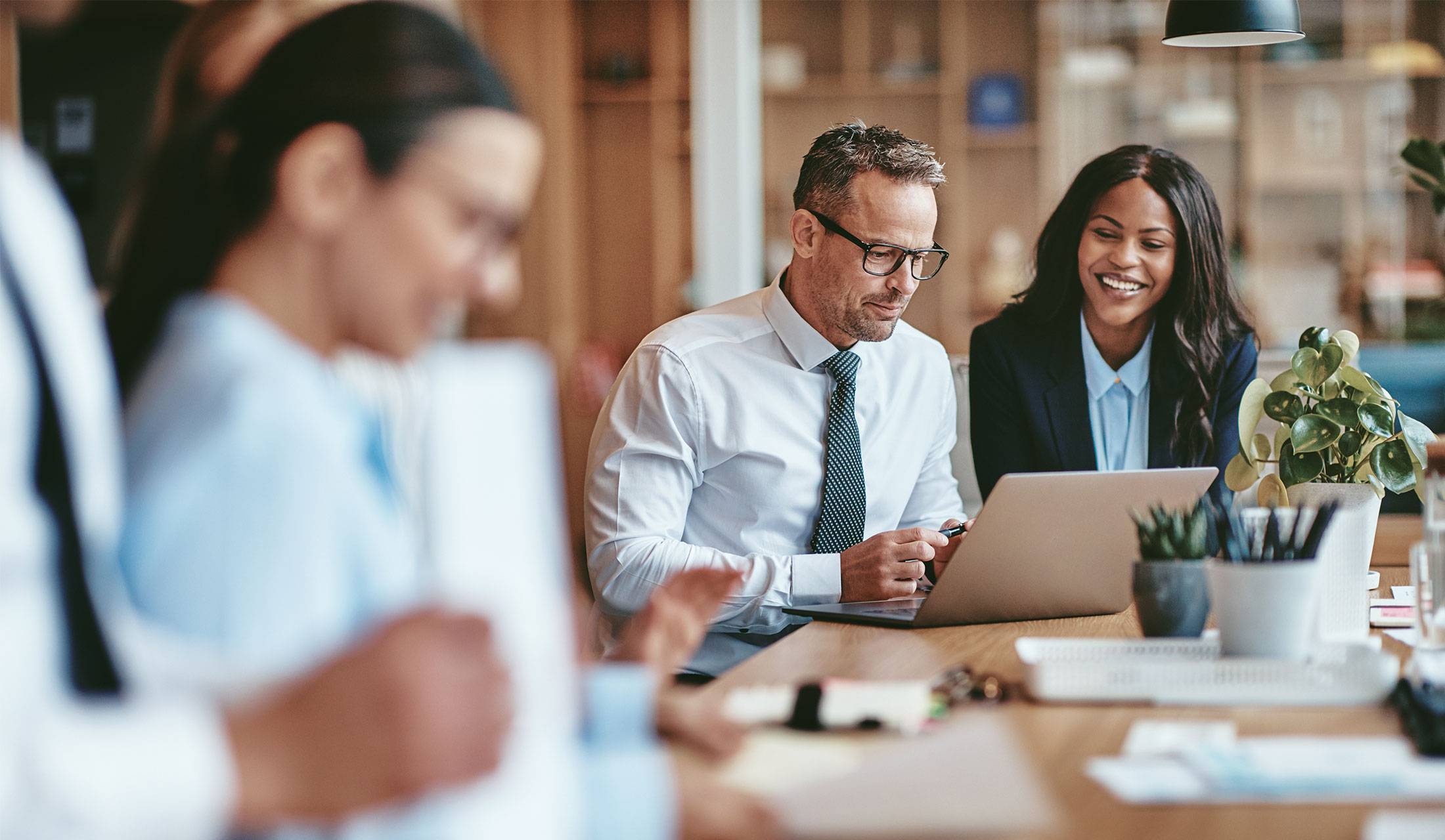 Business partners having a discussion and looking at a laptop