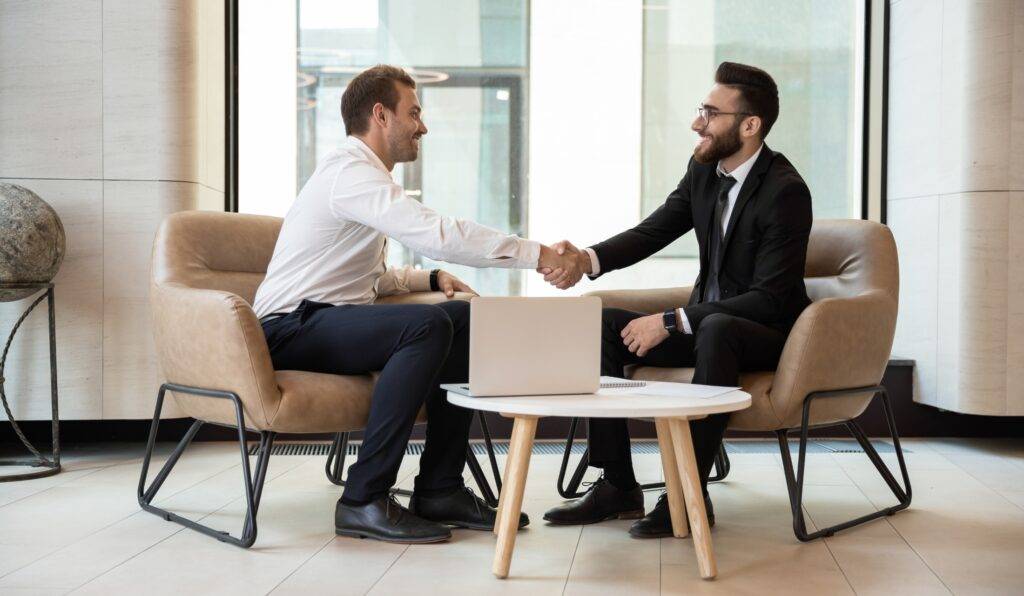 Two men in suits shaking hands in a business agreement